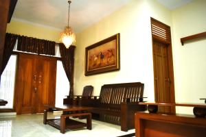 a living room with a bench and a painting on the wall at Pondok Sukamanah Tasik in Tasikmalaya