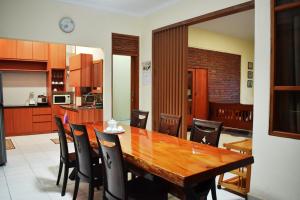 a kitchen and dining room with a wooden table and chairs at Pondok Sukamanah Tasik in Tasikmalaya