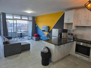 eine Küche und ein Wohnzimmer mit Sofa und Tisch in der Unterkunft 12-0-ONE on 10 South Beach in Durban