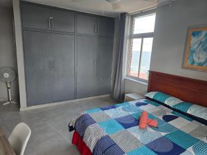 ein Schlafzimmer mit einem Bett und einem Fenster in der Unterkunft 12-0-ONE on 10 South Beach in Durban