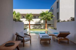 a patio with chairs and tables and a swimming pool at Castello Boutique Suites by the sea - Adults Only in Sissi
