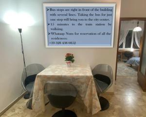 a table with chairs and a sign on the wall at Rooms in Ancona with private bathrooms in Ancona