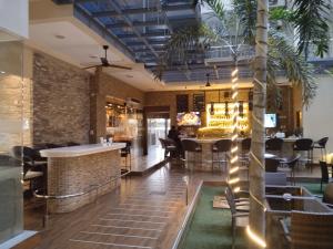 a lobby with a bar and a palm tree at Luxurious Penthouse La Grande Résidence with Home Theater & Netflix in Angeles