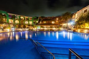 a large swimming pool at night with lights at Ocean Point Beach Resort & Spa Adults Only in Saint Johnʼs