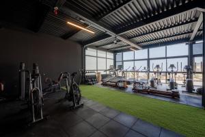 a gym with bikes and exercise equipment and a large window at Nobi Boutique Surf Hotel Taghazout in Tamraght Ouzdar