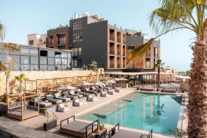 an image of a hotel with a pool and palm trees at Nobi Boutique Surf Hotel Taghazout in Tamraght Ouzdar