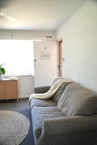 sala de estar con sofá y manta en Harbour Lane Stay, en Geraldton