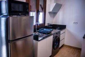 eine Küche mit einem Kühlschrank aus Edelstahl und einem Geschirrspüler in der Unterkunft Vivienda rural La Puentezuela in Grazalema + 11 Fotos