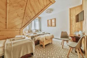 une chambre d'hôtel avec deux lits et un bureau dans l'établissement Willa Swoboda Garden Spa, à Zakopane