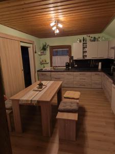 una cucina con tavolo in legno e soffitto in legno di Haus Kraus a Bayerisch Eisenstein