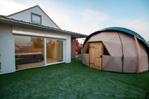 een tent op een gazon naast een huis bij Dôme du levant in Holving