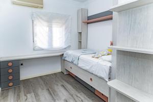 una piccola camera da letto con un letto e una finestra di Villa Daniela a Almería Altre 10 foto