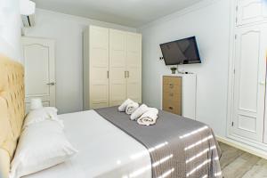 a white bedroom with a bed with towels on it at Villa Daniela in Retamar