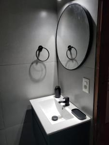 Un baño con un lavabo blanco y un espejo. en Casa para 4 personas con parrillero, en Piriápolis