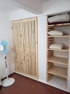 Una habitación con un armario con puertas de madera y un ventilador. en Casa para 4 personas con parrillero, en Piriápolis