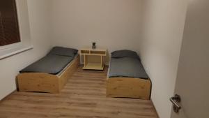 two beds in a small room with a table at Ubytovanie Katka in Liptovský Mikuláš