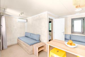 a living room with blue chairs and a table at Armenistis Mediterranean Camping Village in Sarti