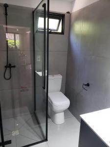 Un baño con inodoro y ducha de cristal. en Casa para 4 personas con parrillero, en Piriápolis 5 fotos más