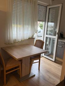 einen Holztisch und Stühle in einem Zimmer mit Fenster in der Unterkunft 2 Soul Appart in Dresden + 4 Fotos