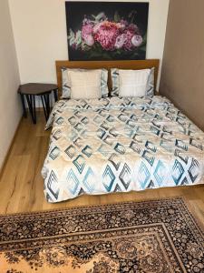 ein Bett mit einer Bettdecke und einem Teppich in einem Schlafzimmer in der Unterkunft 2 Soul Appart in Dresden