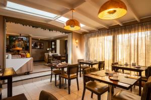 ein Restaurant mit Tischen und Stühlen in einem Raum in der Unterkunft Teclados Hotel in Santiago