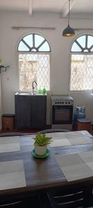 eine Küche mit einem Tisch, einem Waschbecken und 2 Fenstern in der Unterkunft Apartment no17 in Galle