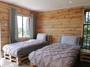 zwei Betten in einem Zimmer mit Holzwänden in der Unterkunft Wooden Cottage for 5 Near Lake Naivasha, Elwai Visitor Centre in Heni Village