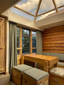 Zimmer mit einem Holztisch und einem Fenster in der Unterkunft Wooden Cottage for 5 Near Lake Naivasha, Elwai Visitor Centre in Heni Village
