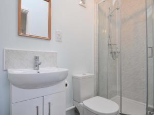 Un baño con lavabo, inodoro y ducha. en Violet's Rest, en Exeter