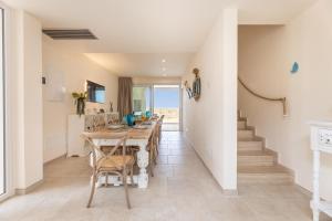 托雷桑塔萨宾娜Villa Regina Sul Mare的厨房以及带桌子和楼梯的用餐室。