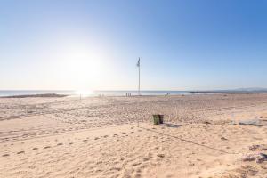 コスタ・ダ・カパリカにあるGuestReady - Cozy Beachside Retreatの砂の中に旗竿が立っているビーチ