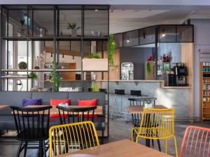 Un restaurante con mesas y sillas en una sala. en ibis Kassel Melsungen, en Melsungen