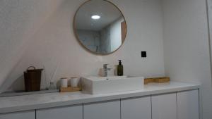 a bathroom with a white sink and a mirror at Green Zone - Vikendica in Dubrave Gornje