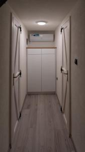 an empty hallway with a white door and wooden floors at Green Zone - Vikendica in Dubrave Gornje