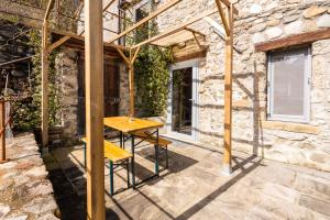 a wooden table in front of a stone building at Le case di Rosie, Mountain view, Tuscany in Gragnola