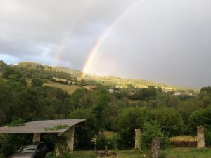 un arco iris en el cielo sobre un campo con una casa en O Coeur d'Anaïah, en Laval-sur-Doulon
