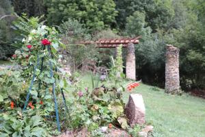 Un jardín con una pérgola y algunas flores. en O Coeur d'Anaïah, en Laval-sur-Doulon