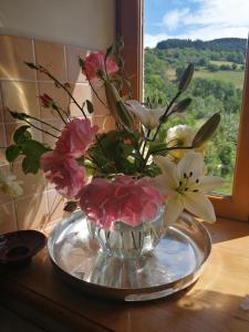 Un jarrón de flores sobre una mesa con una ventana. en O Coeur d'Anaïah, en Laval-sur-Doulon 8 fotos más