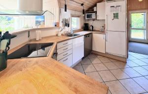 una cucina con mobili bianchi e un frigorifero bianco di Nice Home In Løkken a Lyngbytorp