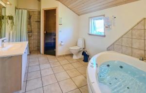 un bagno con vasca, WC e lavandino di Nice Home In Løkken a Lyngbytorp Altre 24 foto