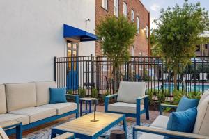 a patio with couches and chairs in front of a building at The Ray Soulful King Studio Pool in Jacksonville