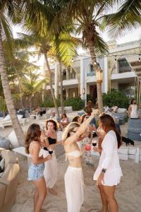 un gruppo di donne in piedi sulla spiaggia di Sana Tulum Beachfront Boutique Hotel a Tulum