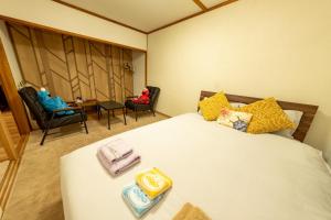 a bedroom with a bed with towels on it at BUDDY HOUSE - Newコスパ重視! サンタプレゼントパーク10分! カムイリンクス28分! コンビニ徒歩3分! 旭川鷹栖インター5分! 商業施設すぐ! in Asahikawa