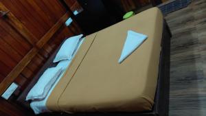 a bed in a room with a pillow on it at Jackroot Heritage wood villa Athirappilly in Kallana