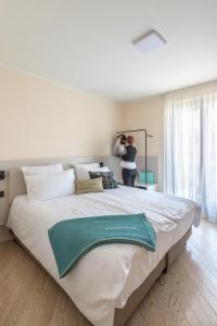 a woman taking a picture of a large bed at WANDERLUST VILLETTE a SCHIERA - Bardolino, Lago di Garda - Verona in Bardolino