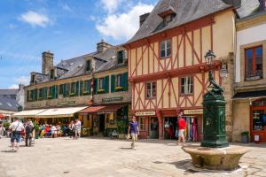 a group of people walking around a street with buildings at Logement avec terrasse et parking in Concarneau