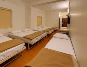 Giường trong phòng chung tại Hotel Parag Deluxe Kolhapur