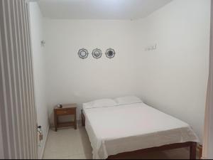 a bedroom with a bed and two clocks on the wall at Hotel Comercial Neiva EZ in Neiva