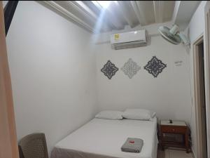 a small bedroom with a bed and a light at Hotel Comercial Neiva EZ in Neiva