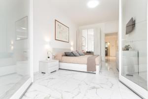 a white bedroom with a bed and a mirror at Il Sogno a due passi dal mare vicino PORTOFINO in Rapallo